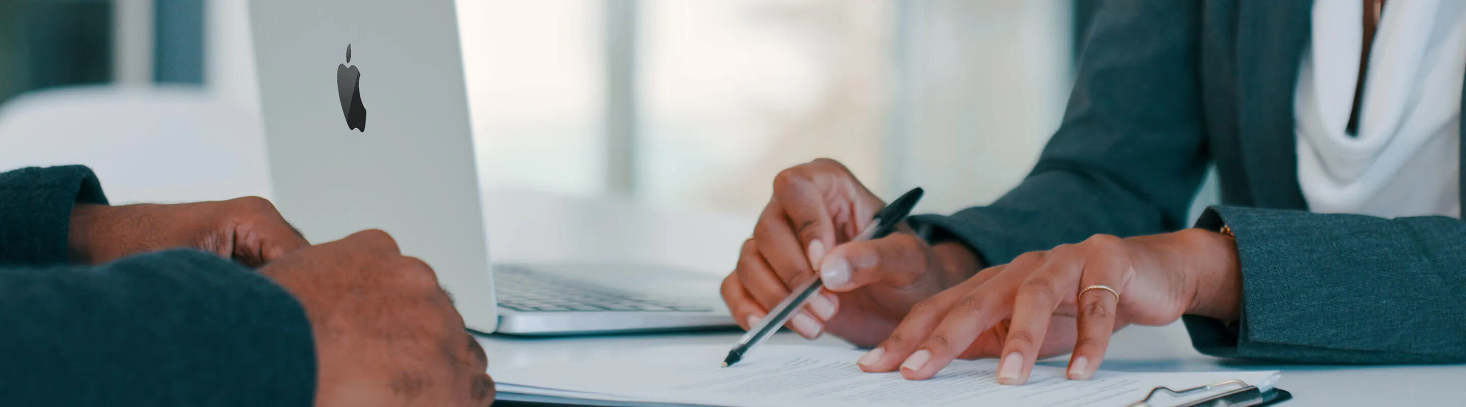 People chatting around a MacBook