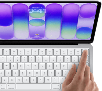 MacBook Neo, silver colour, showing login screen, person's finger on Touch ID sensor in top-right corner of keyboard