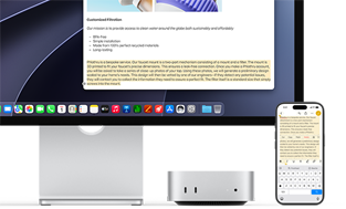 Mac mini front, tucked under Studio Display, an iPhone sits to the right of the device and the display, text selected with cut, copy, paste and AutoFill commands above on iPhone matches highlighted text on display, showcasing Universal Clipboard