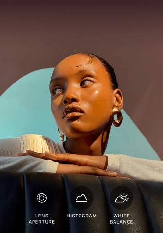 Close up portrait of a well-lit model with a colourful background, demonstrating the pro camera system's Pro controls UI: Lens Aperture, Histogram, White Balance