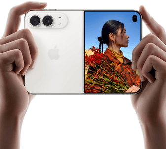 iPhone Duo, Star White colour, held by two hands in horizontal orientation, unfolded, left panel shows 48MP Dual Fusion rear cameras, right panel shows person getting their picture taken on outer display, the subject of the photo is able to see their face as their picture is getting taken using Duo Preview